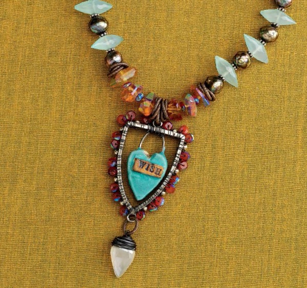 The Wish Me Luck necklace by Erin Prais-Hintz uses an open-back bezel to create a shadowbox pendant.