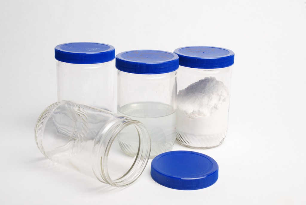 Peanut butter jars filled with studio materials like patina, ammonia, acetone, baking soda